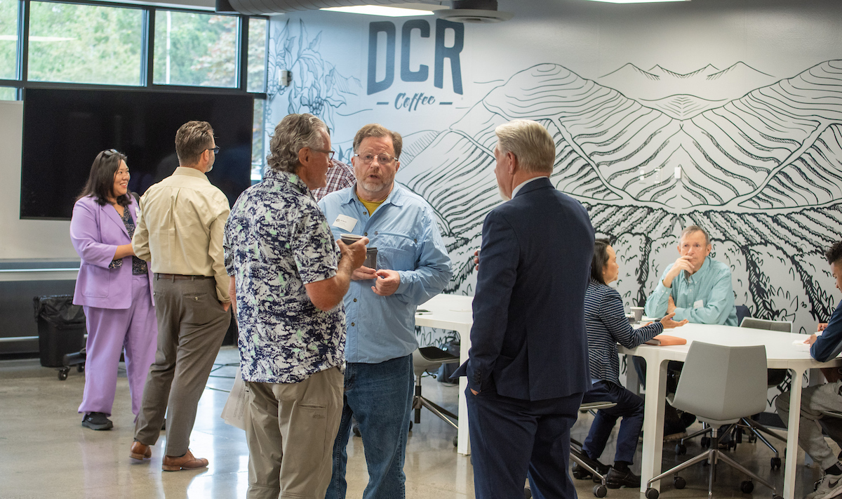 A group of people standing and talking in a modern office building.