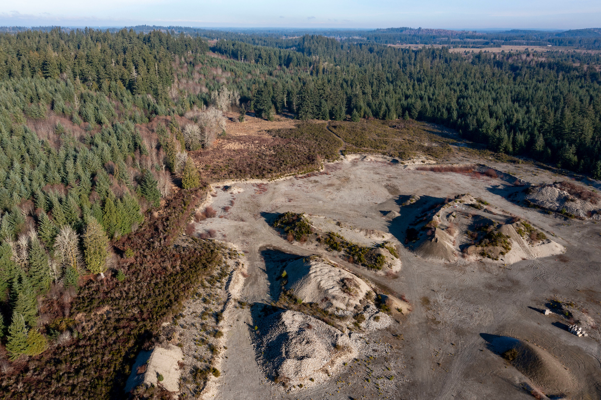 An aerial shot of a gravel mining area surrounded by forest.