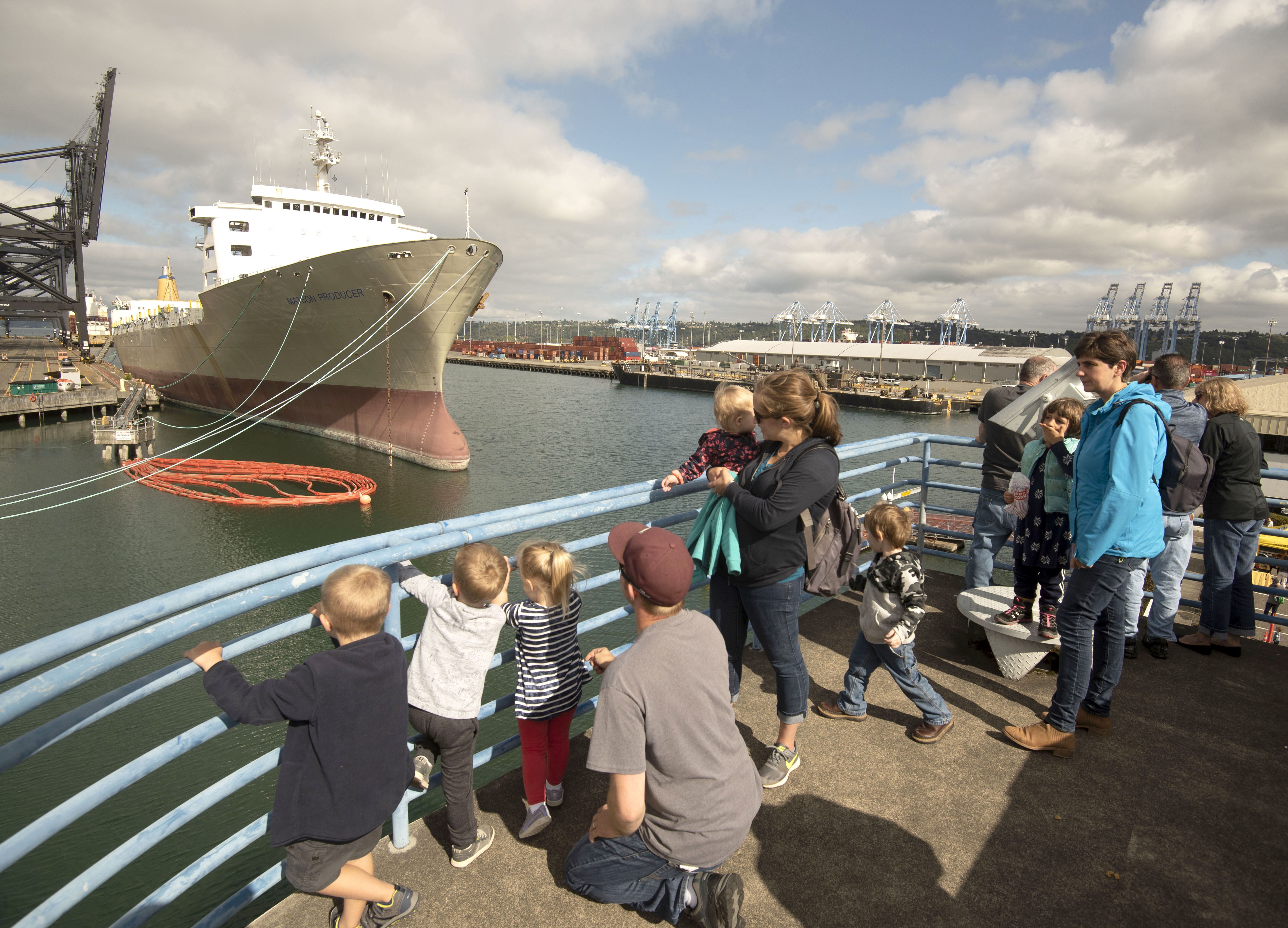 A group of people overlook a ship in a waterway.