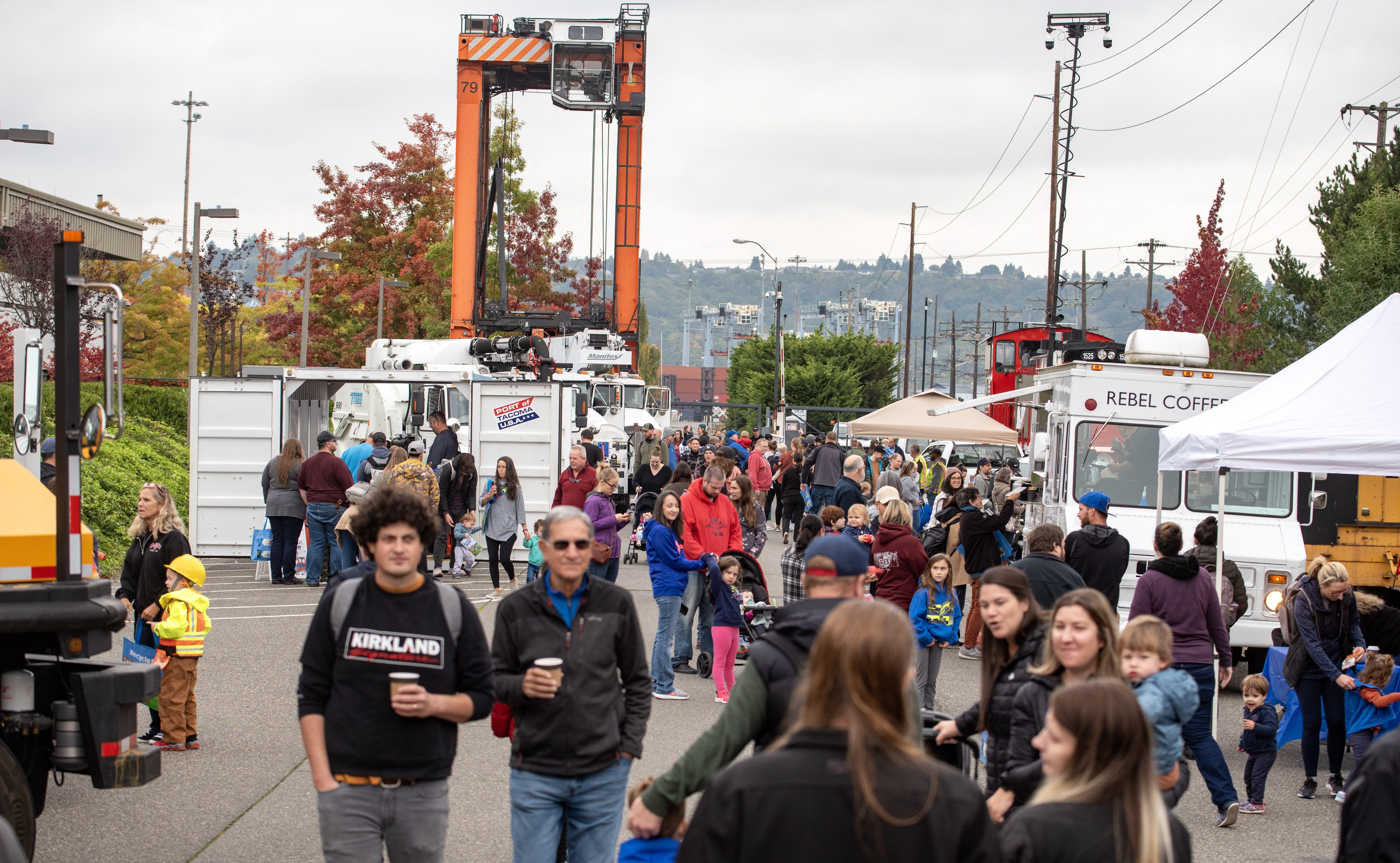A large group of people walk through the grounds of an event.