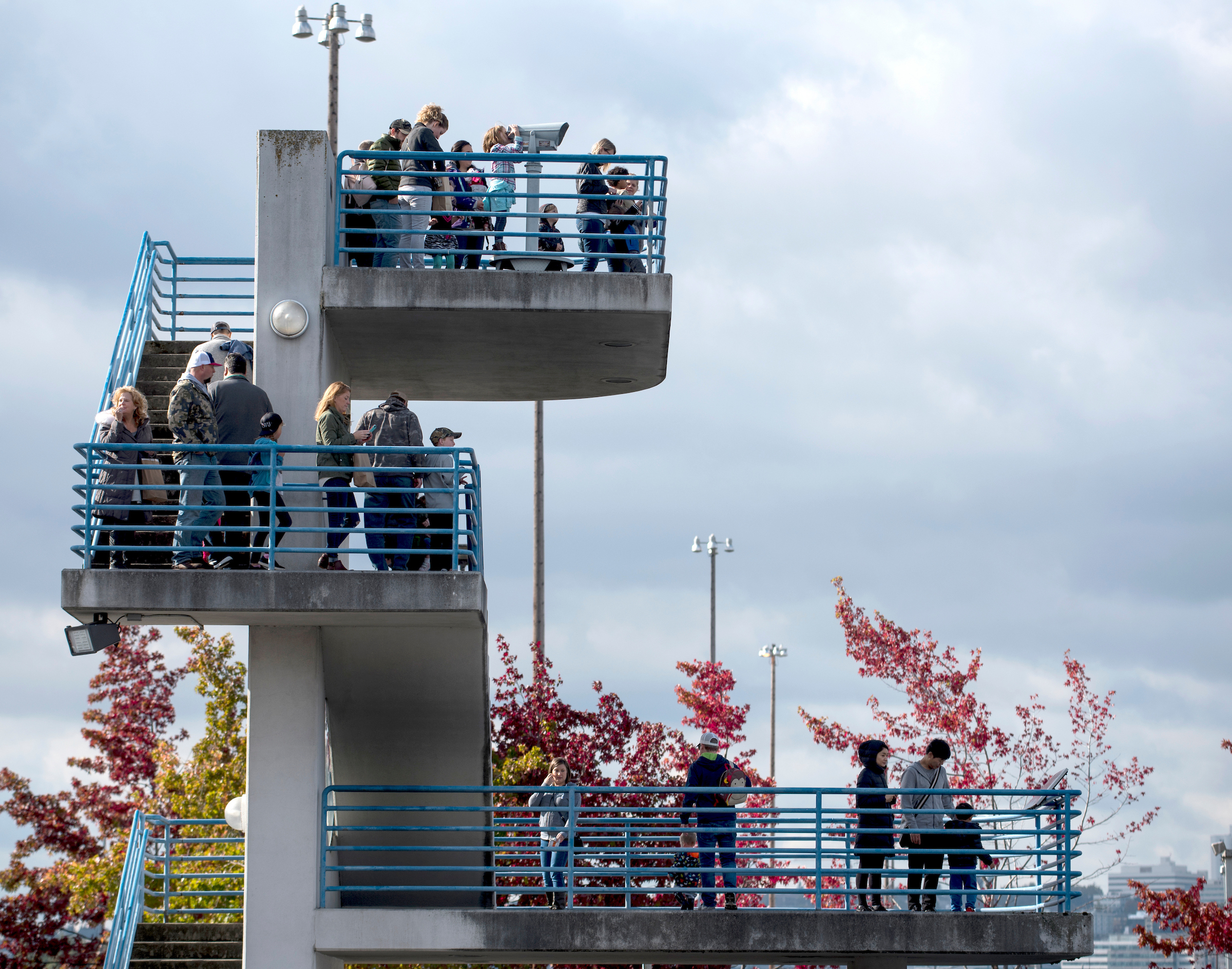 A group of people on three ascending platforms look out at the sights.
