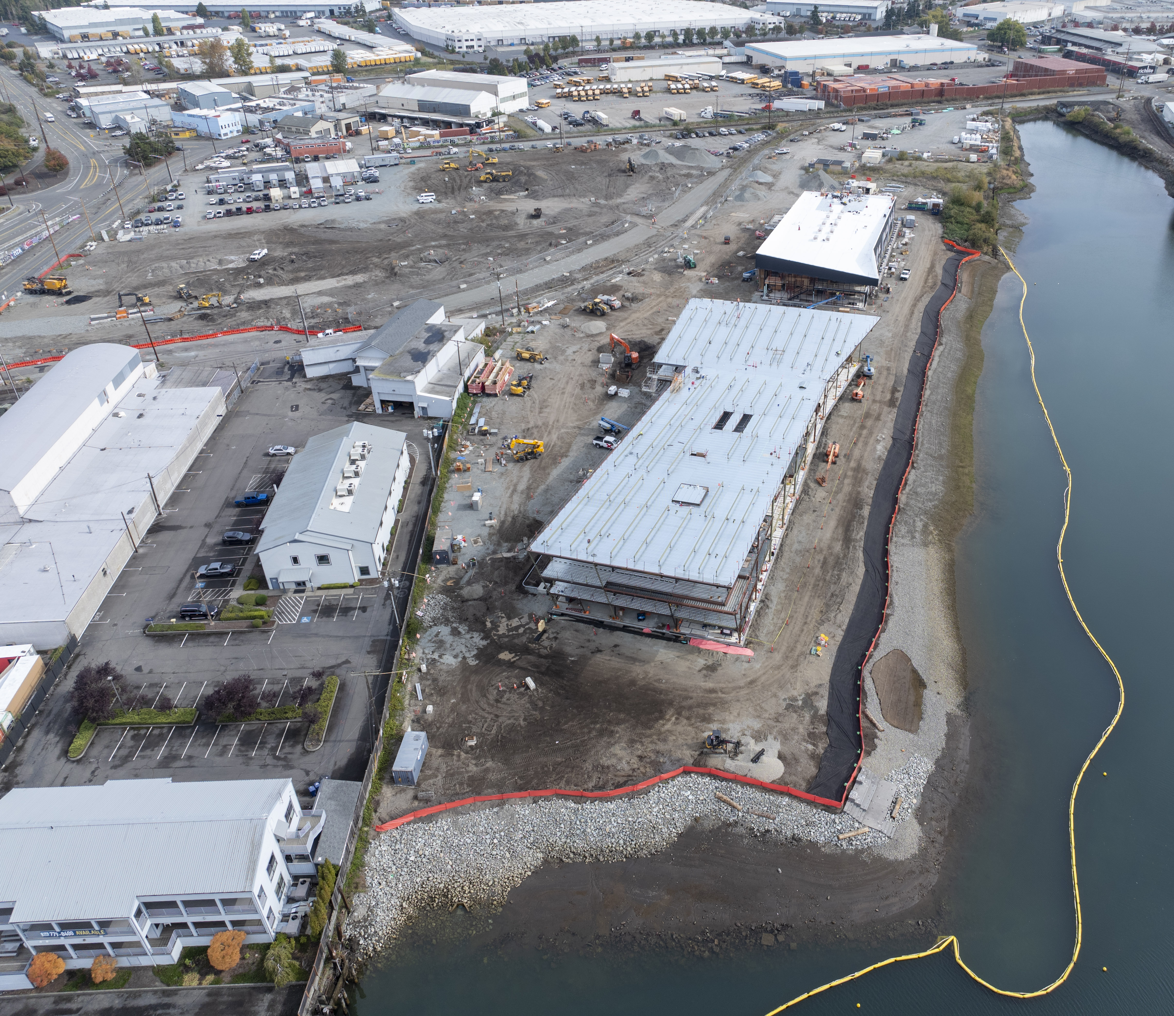 Aerial shot of a building construction site along a shore.