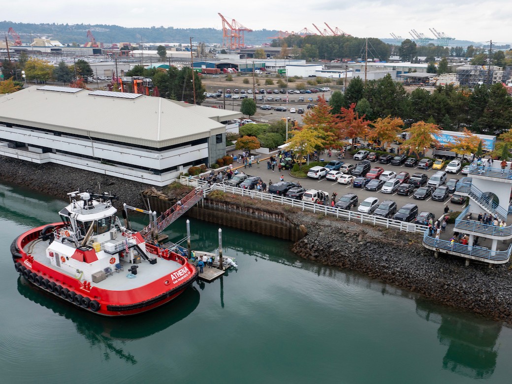 Aerial view of a port terminal with a red and white tugboat at a Port event 