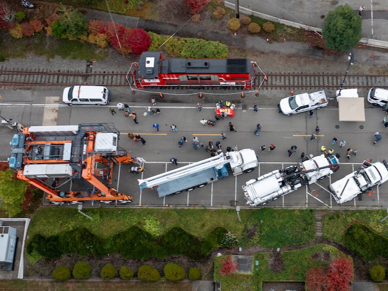 Aerial shot of a street lined with trucks and people moving through it. 
