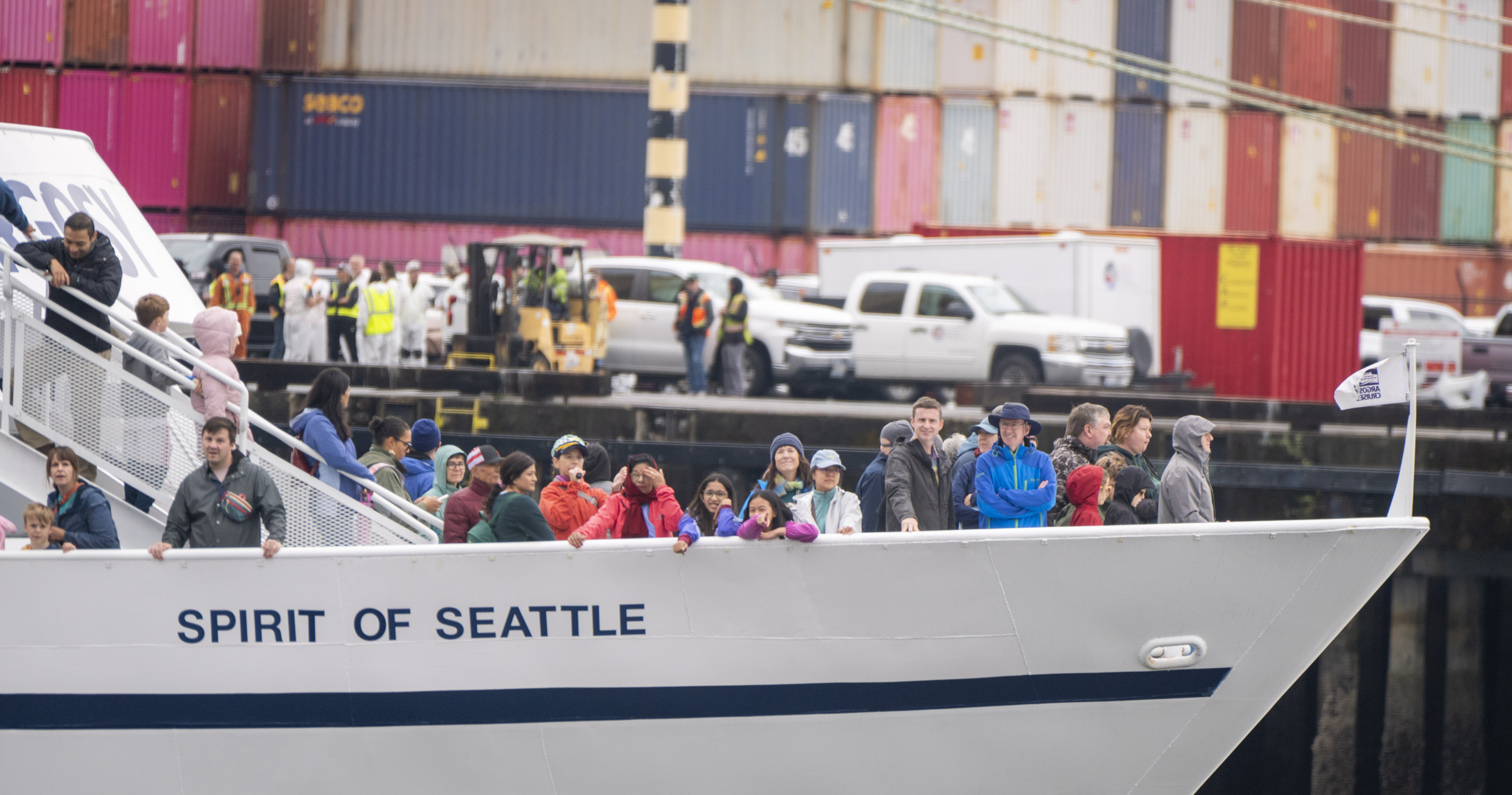 People taking a boat tour of the Port of Tacoma look out over the bow of a cruise ship
