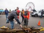 Students in protective gear looking at a technician explaining the parts of a rail track.