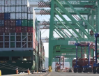 A port terminal with a vessel being unloaded by cranes.