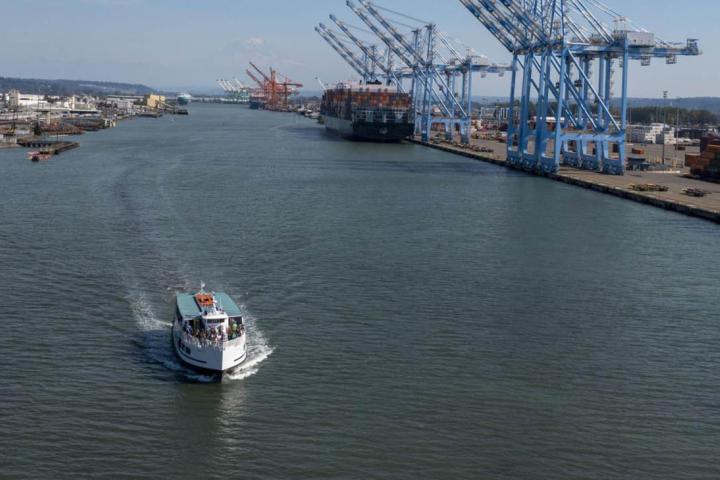 A Port of Tacoma boat tour - a passenger ferry moves through a waterway near container cranes.