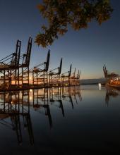 Port cranes reflected off the water at sunset