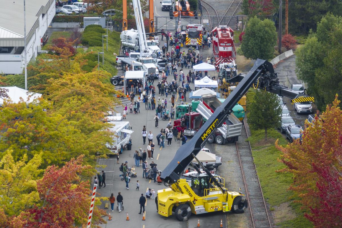 Overhead shot of a street lined with people and construction vehicles.