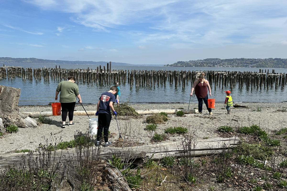 A group of people cleaning up trash on a beach.