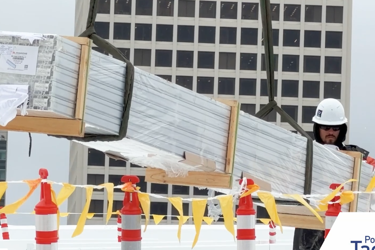 Video still of a construction worker installing solar panels. 