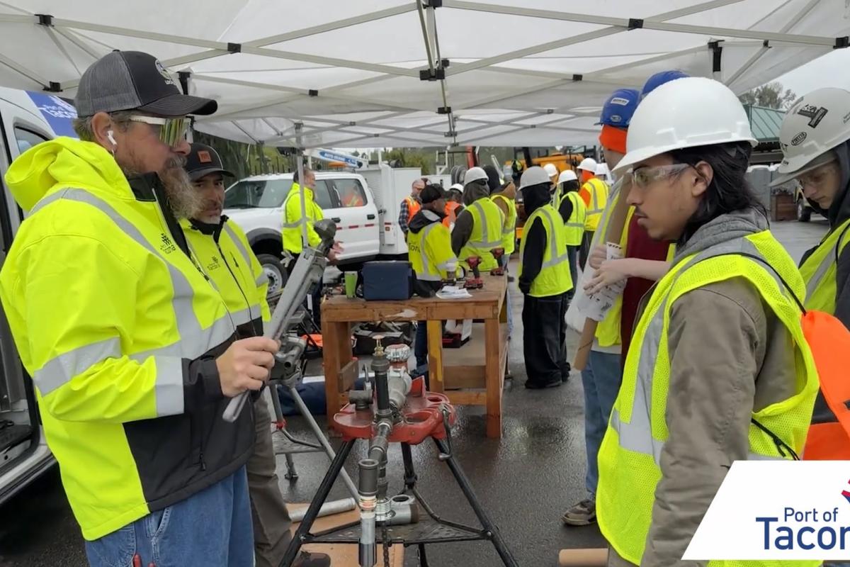 A student in a reflective vest and hard hat speaks to a vendor at Pierce County Construction Career Day 2026