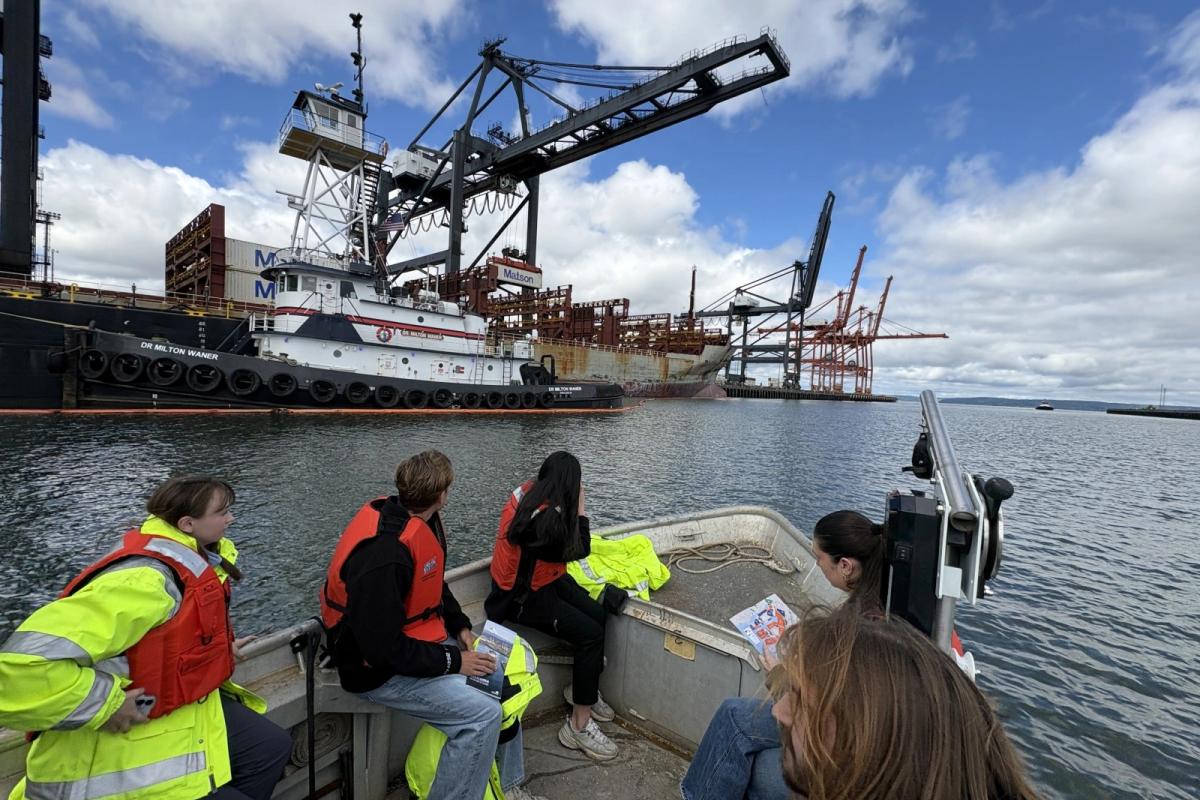 A group of interns ride a boat through the Port of Tacoma.