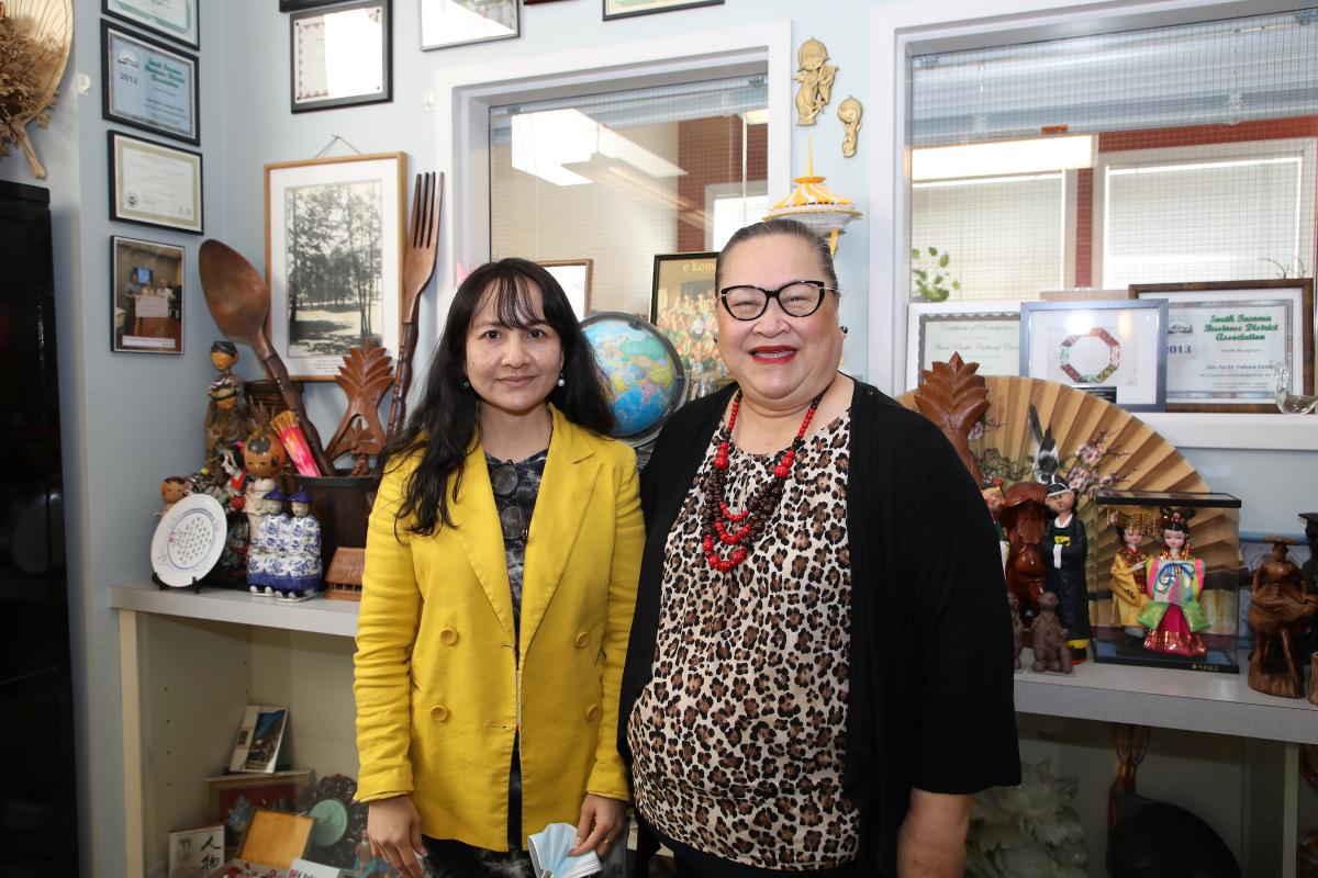photo of two women standing in front of art displays