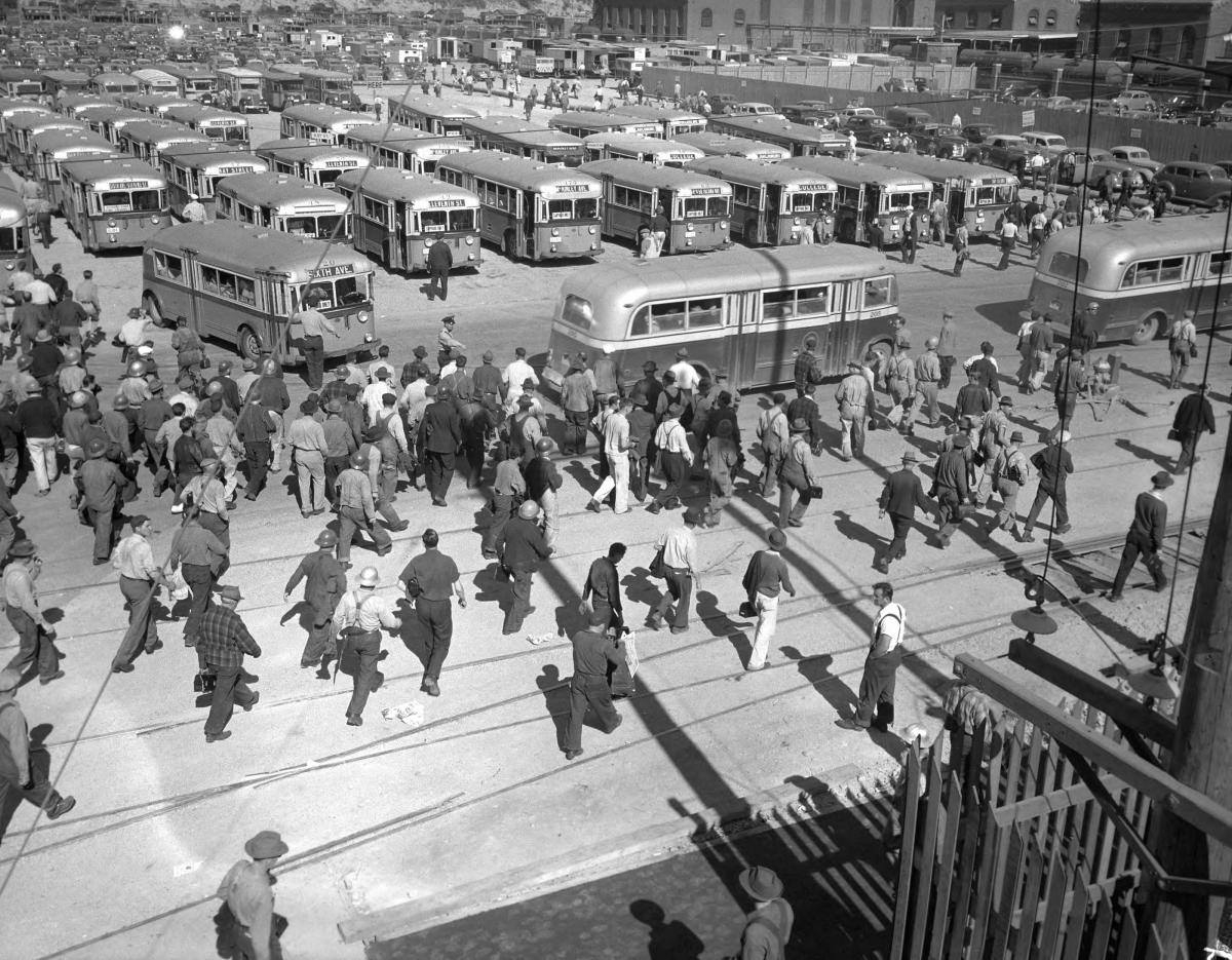 historical photo of people getting out of buses