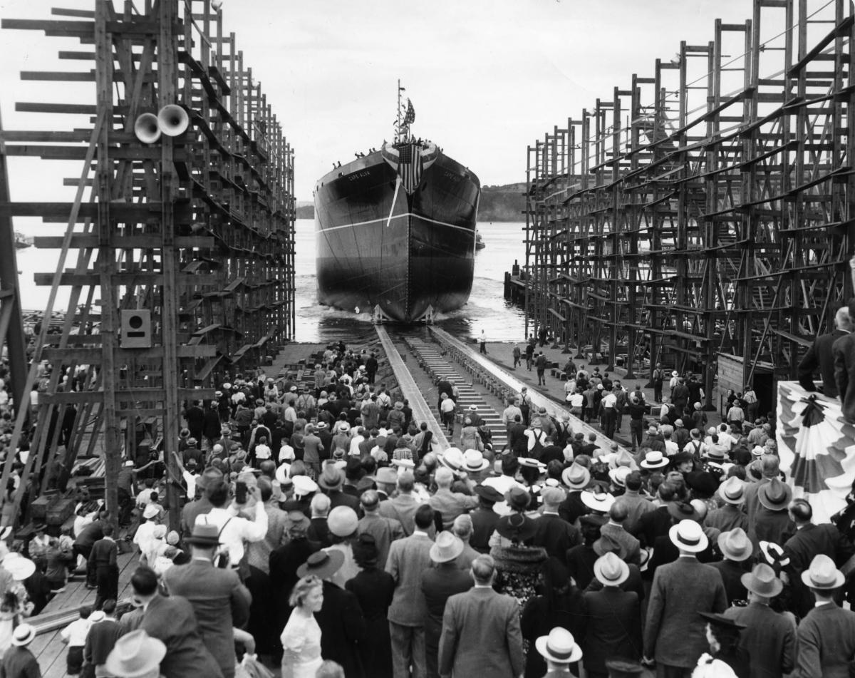 historical photo of people gathered to watch a vessel being launch