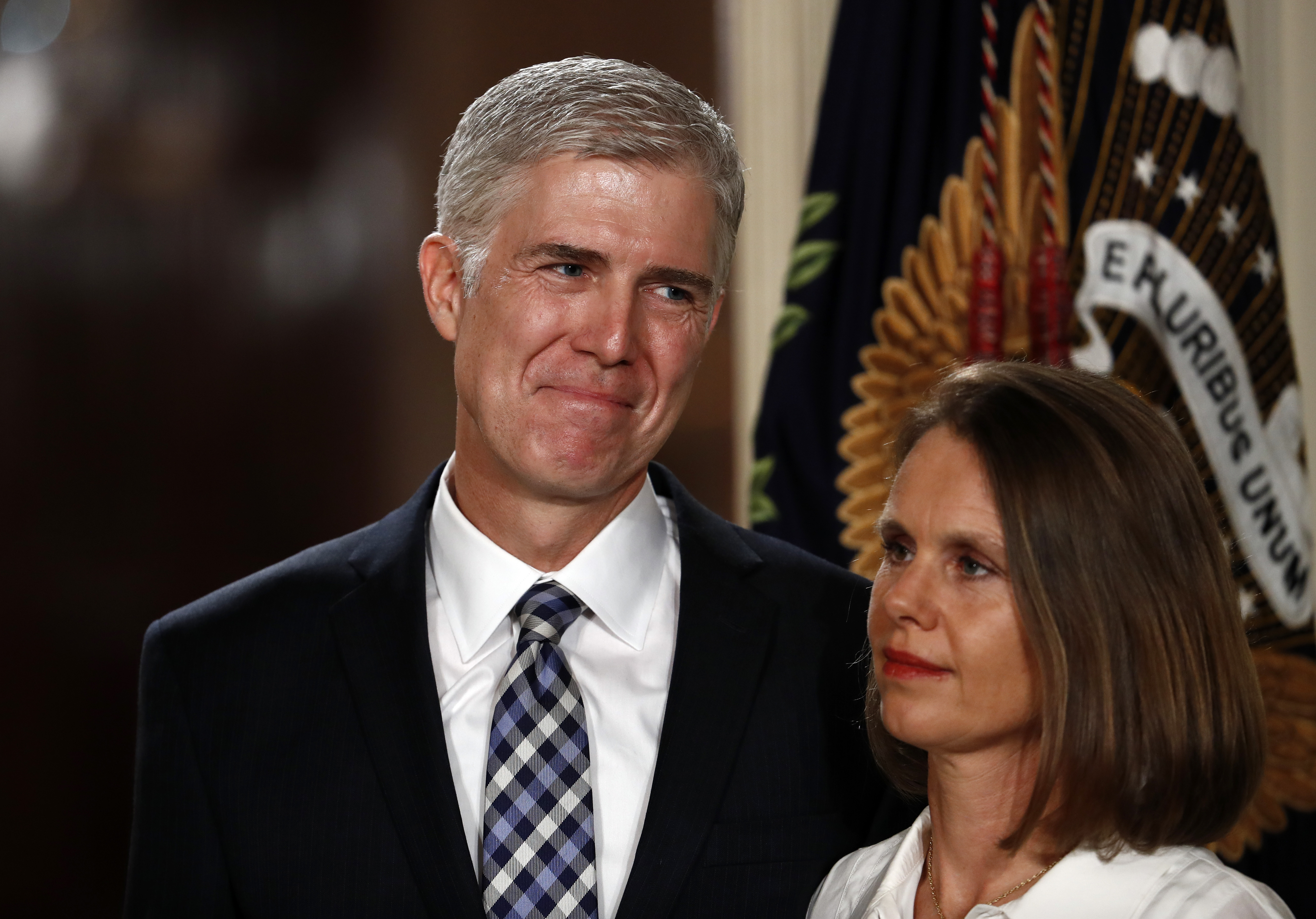 El magistrado designado a la Corte Suprema, Neil Gorsuch se encuentra con su esposa Louise mientras el presidente Donald Trump habla en la Sala Este de la Casa Blanca en Washington. AP