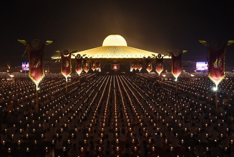 Miles de devotos budistas participan en las oraciones de la tarde a la luz de las velas para conmemorar el día de Makha Bucha en el templo de Wat Dhammakaya, justo al norte de Bangkok, Tailandia. LA PRENSA/AFP