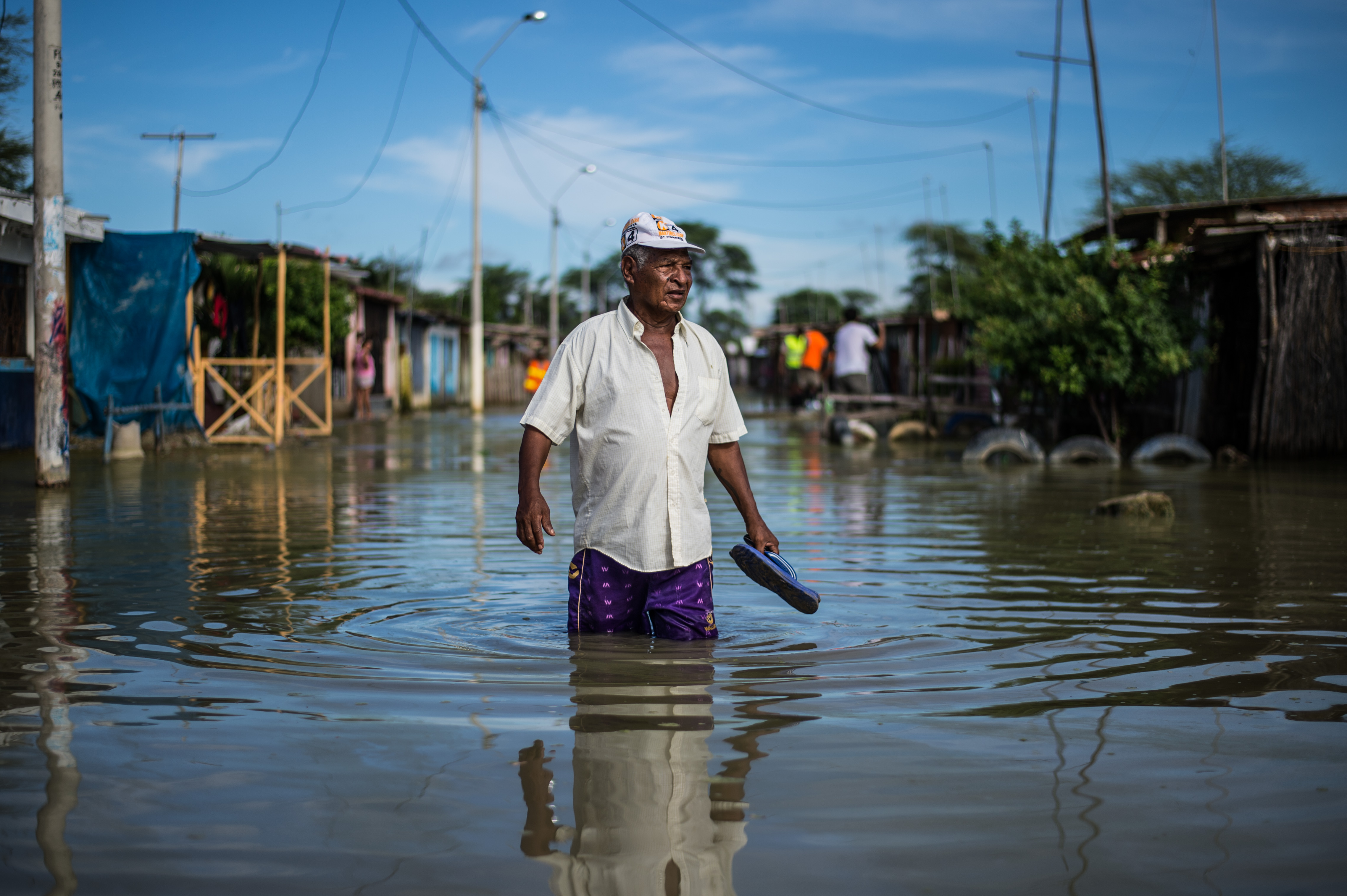 Un hombre camina a través del agua sucia en una calle en las afueras de Piura, al norte de Perú. Esta zona ha sido una de las más afectadas por el fenómeno climático de El Niño, el cual ha causado que los ríos se desborden por toda la costa peruana, aislando comunidades y barrios. LA PRENSA/AFP