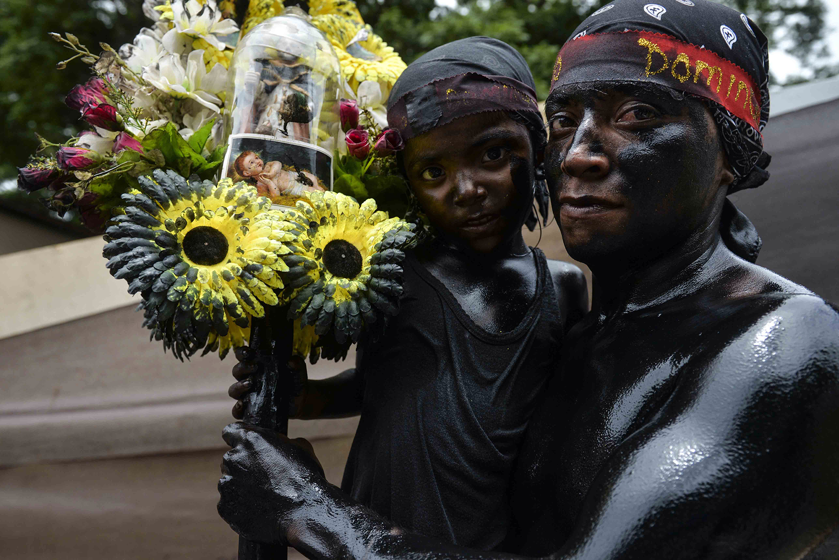 Padre e hijo se llenaron el cuerpo de aceite negro para pagar sus promesas a Santo Domingo. LA PRENSA / Jader Flores.