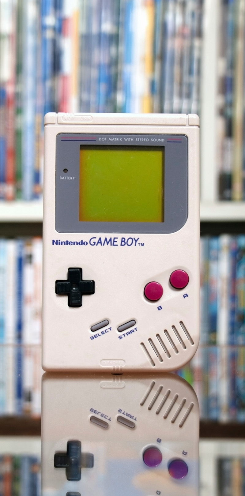 Consola portátil compacta de diseño retro inspirada en los años noventa, destacando su brillante pantalla y botones clásicos.