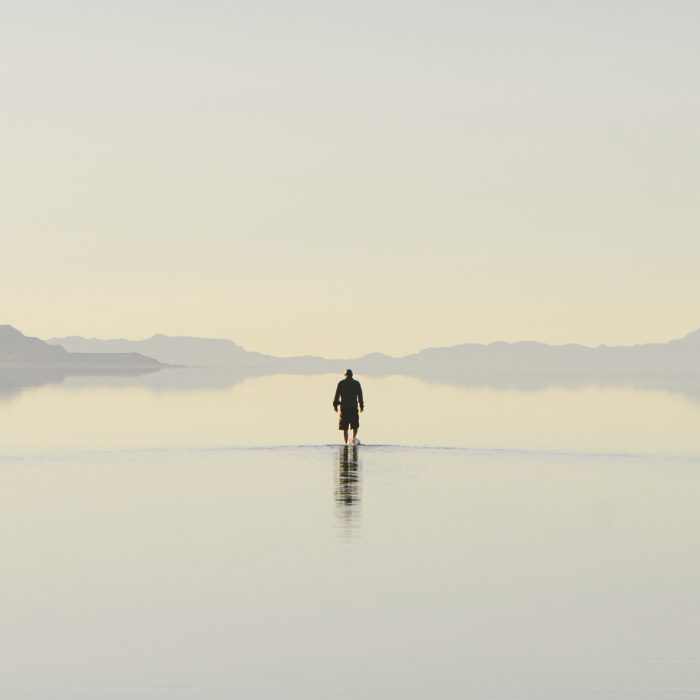 Fotografía de paisaje a gran escala mostrando un cuerpo de agua grisáceo en contraste con una imponente estructura de hormigón.