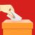 Hand putting voting paper in the ballot box, Voting concept