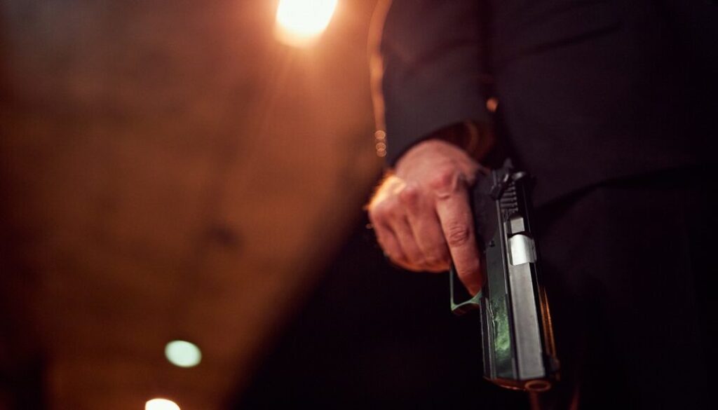 Unrecognizable person holding a handgun at night