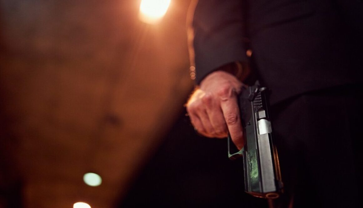 Unrecognizable person holding a handgun at night