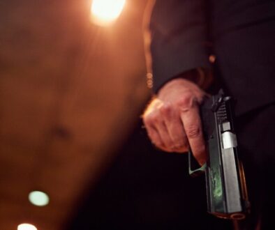 Unrecognizable person holding a handgun at night
