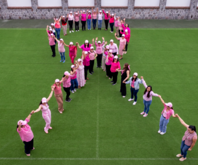 Mujeres formando un lazo rosa