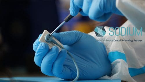 Schick sensor repair: a Sodium Dental technician working on the cable connection of a Schick x-ray sensor
