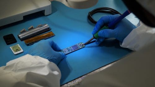 Kodak sensor repair: a Sodium Dental technician soldering the circuit board of a Kodak RVG 6100 sensor