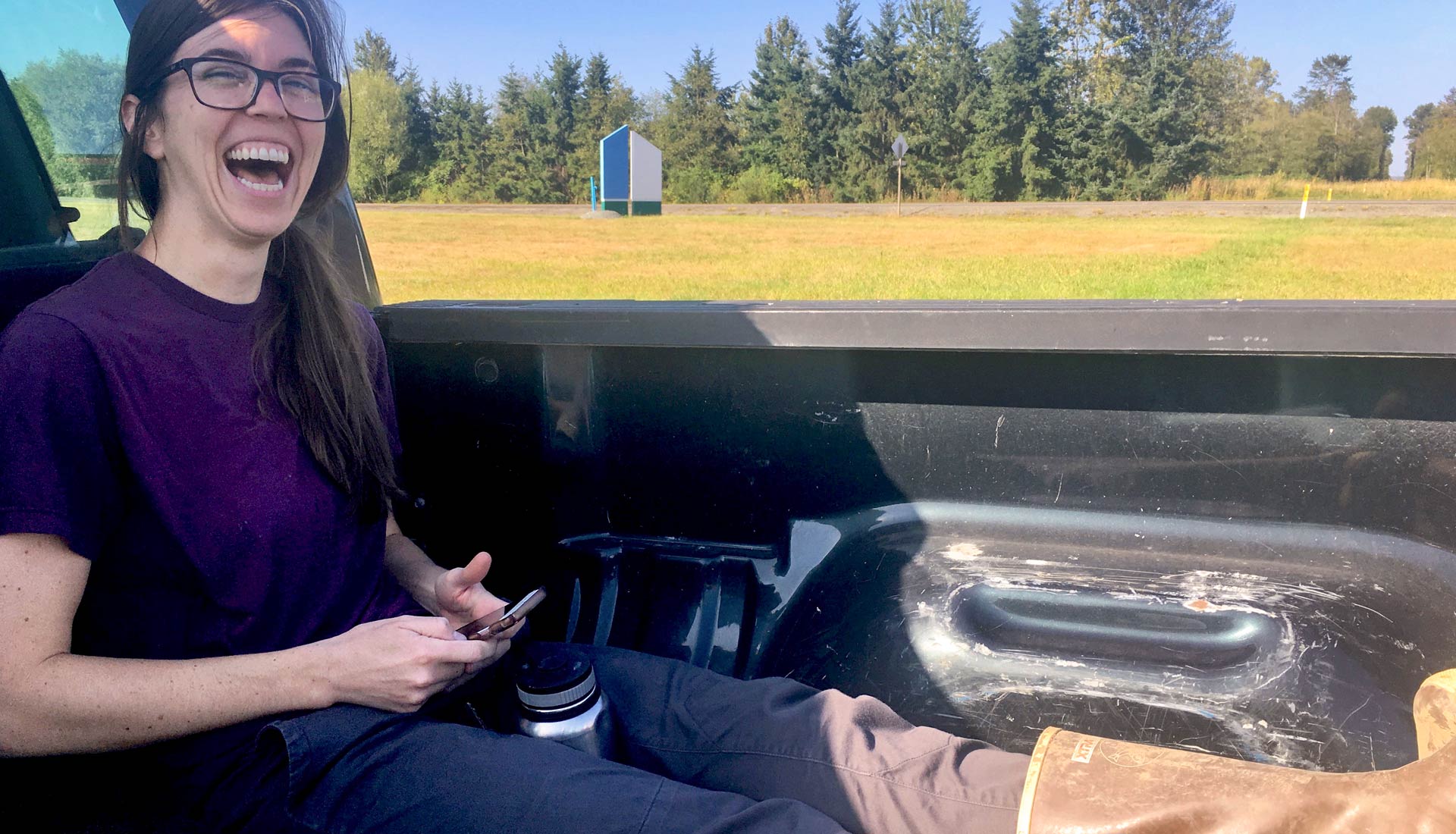 Laughing woman in the bed of a pickup truck