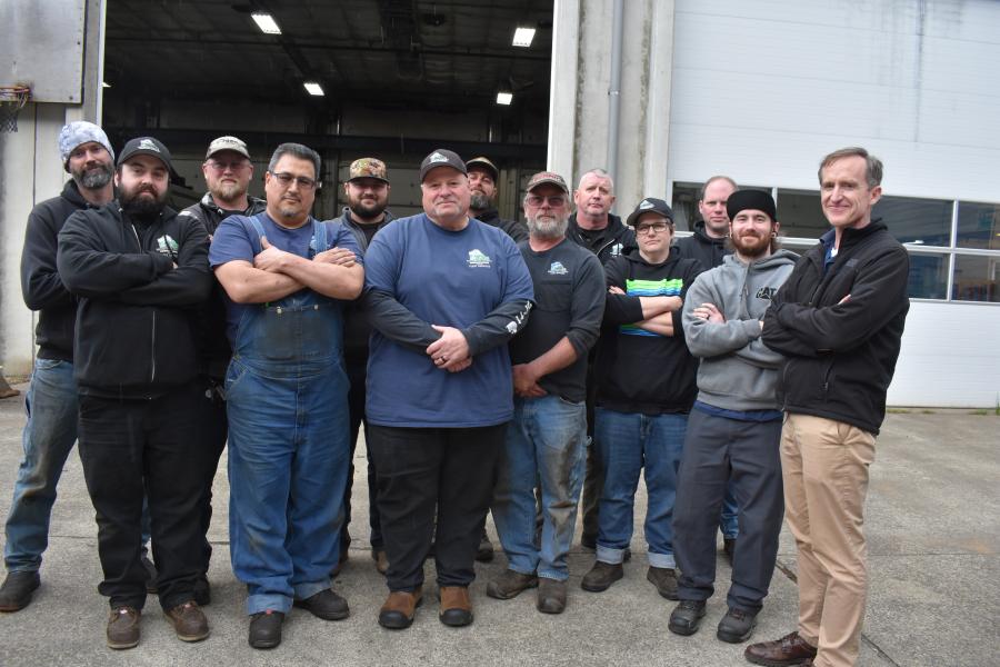 13 members of thurston county fleet services team stand in front of a county garage door