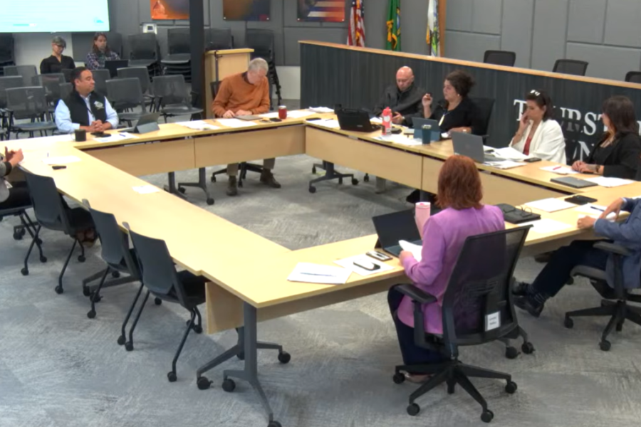 Image from a county budget meeting inside the Commissioners Board room with thurston county commissioners and county leaders sitting around a table.