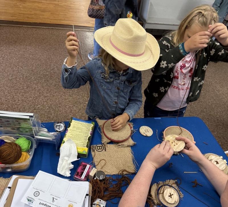 Two kids learning to sew buttons.