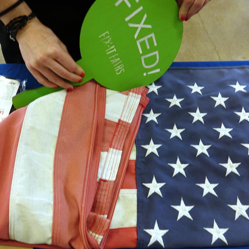 An American flag on a table with a sign that says Fixed.