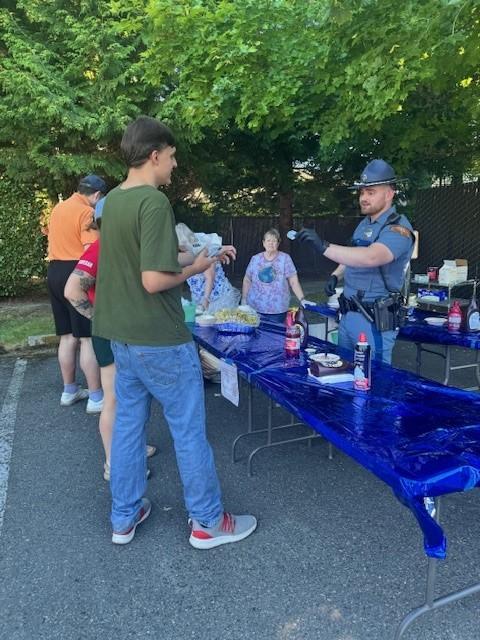 Photo of state trooper serving ice cream at Project SAFER ice cream social event