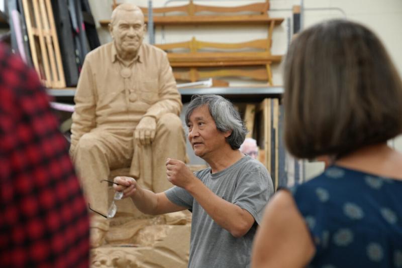  September 5, 2024: artist Haiying Wu addresses a group visiting his workspace. Wu has completed most of this work on the top half of the clay model. ArtsWA and the Nisqually Indian Tribe partnered with South Puget Sound Community College to host Haiying while he works.