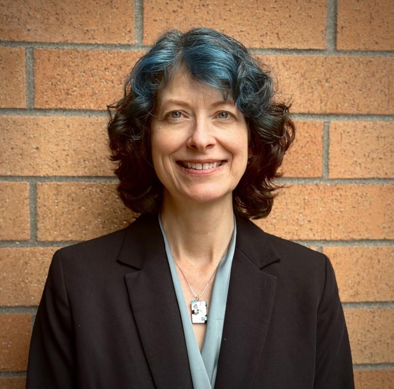 Image of Thurston County Health Officer Dr. Barbra Villona standing in front of brick wall for headshot