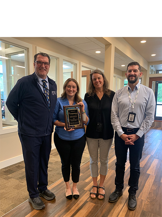 photo of four people receiving a thank you plaque