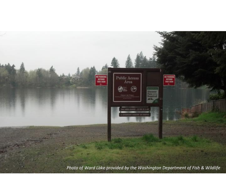 A photo of Ward Lake in Thurston County from water's edge on an overcast day with the brown Lake Sign