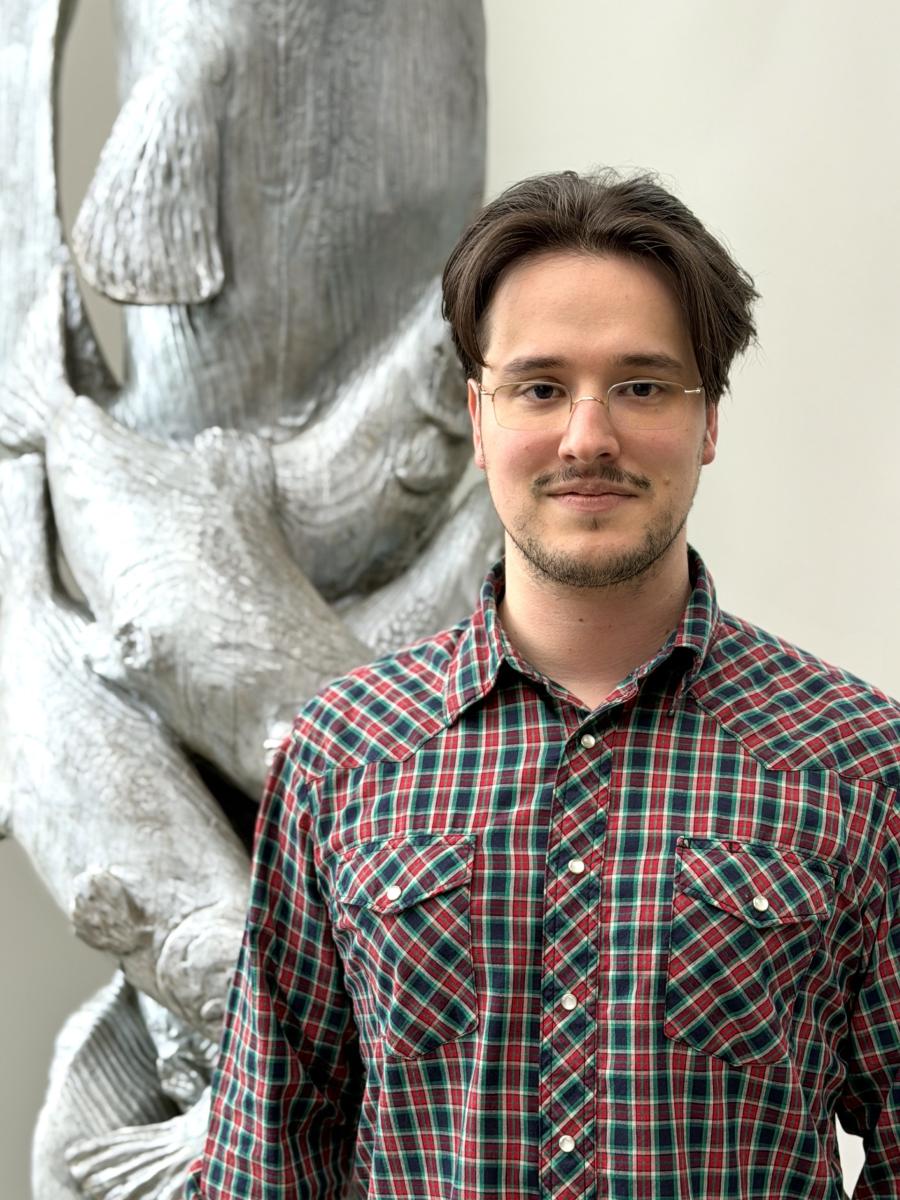 Bryan Benjamin, Thurston County's Natural Resources Program Manager standing in front of a sculpture of salmon