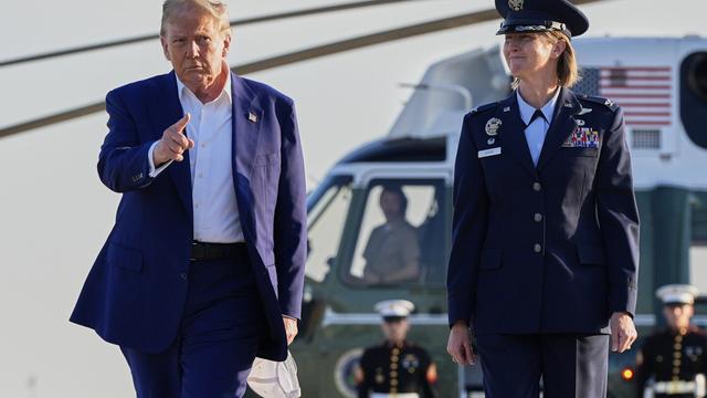 President Donald Trump, left, escorted by Air Force Col. Angela F. Ochoa, Commander, 89th Airlift Wing, walks from Marine One to board Air Force One, Tuesday, June 24, 2025, at Joint Base Andrews, Md. (AP Photo/Alex Brandon)
