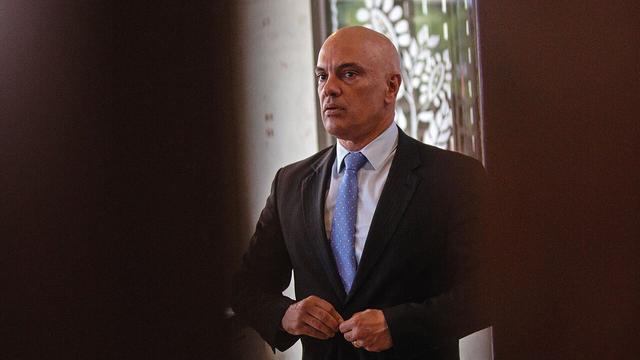 Alexandre de Moraes buttoning up his suit