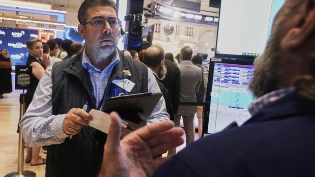 Trader Michael Capolino left, works on the floor of the New York Stock Exchange, Monday, Aug. 18, 2025. (AP Photo/Richard Drew)