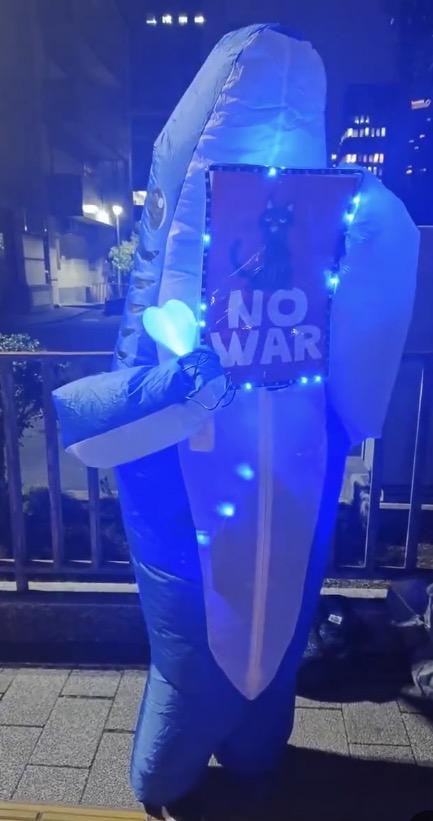 NOWARのプラカードを掲げるサメ光っている