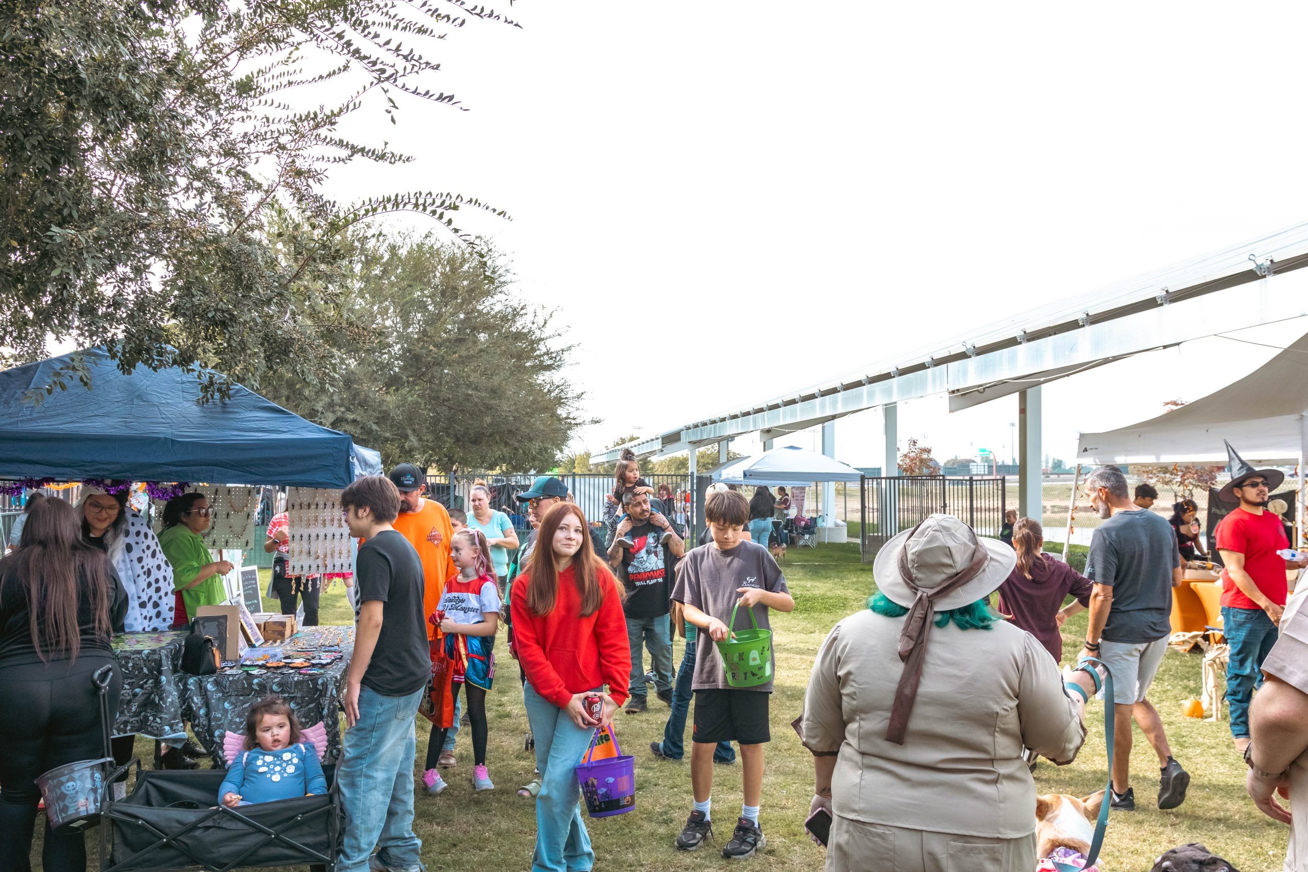 Costumed guests exploring outdoor vendor booths at Trunk-or-Treat